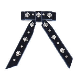 Detail of dark blue velvet bow clip with floral rhinestone and pearl embellishments