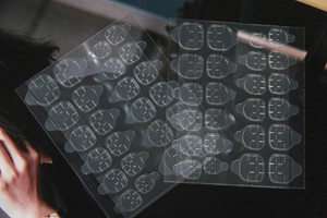 Transparent waterproof nail glue tabs for press-on nails with various sizes on a sheet