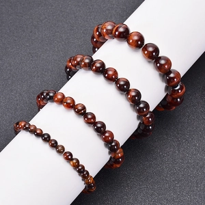 Natural red tiger eye stone beaded bracelets in various sizes on a white display
