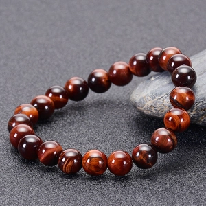 Close-up of red tiger eye stone bracelet beads showing natural chatoyancy and silk luster