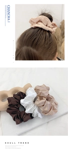 Detailed texture of satin scrunchies in champagne and white with model hair styling