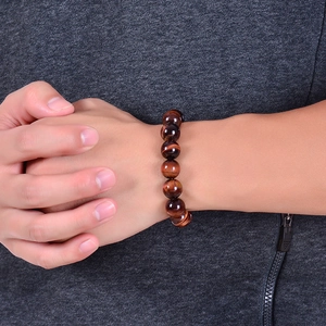 Natural red tiger eye stone beaded bracelet with polished round beads on a model wrist