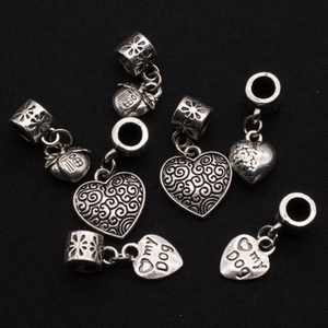 Detailed view of vintage silver alloy charms featuring heart and apple shapes for DIY jewelry