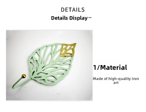 Detail view of leaf shaped iron wall hook in light green with elegant gold leaf tips