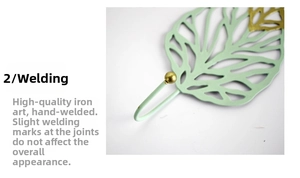 Detailed close-up of leaf-shaped iron wall hook with green and gold manual welding finish