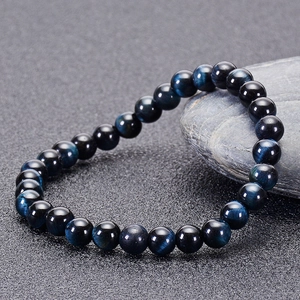 Macro shot of natural blue tiger eye stone beads bracelet with cat-eye luster and texture