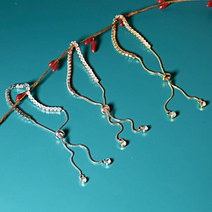 Adjustable 3mm zircon bracelets in gold, silver, and rose gold hanging on a branch