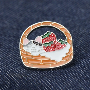 Broche en émail créative avec un chat endormi dans un panier et des fraises