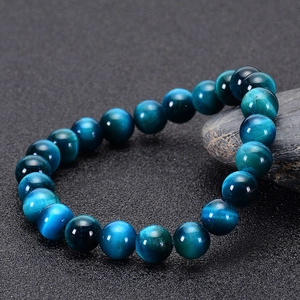 Macro shot of natural blue tiger eye stone beads showing cat-eye effect on the bracelet