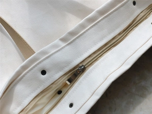 Detailed close-up of a sturdy canvas tote bag featuring a secure metal zipper closure