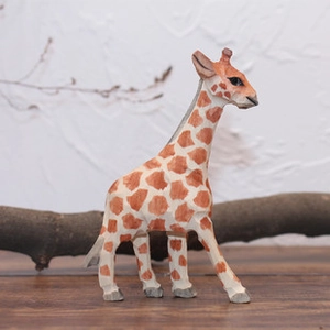 Vue latérale détaillée d'une figurine de girafe en bois sculptée sur une surface en bois