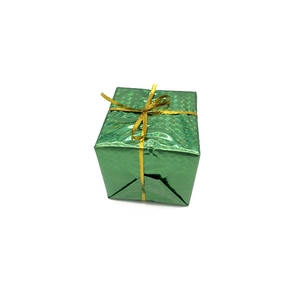 Macro shot of green laser foam gift box with golden ribbon for Christmas tree decor