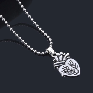 Detail macro shot of a silver anatomical heart pendant with a polished metallic finish