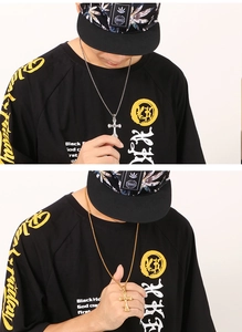 Detailed view of silver and gold cross pendant necklaces with twist chains on a model