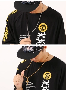 Detail of male model wearing gold and silver stainless steel cross necklaces with engravings