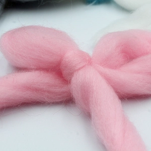 Close-up of a soft pink flocked ribbon Christmas tree ornament with a plush texture