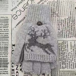 Détail de mitaines en tricot avec motif de renne et fermeture à bouton vintage