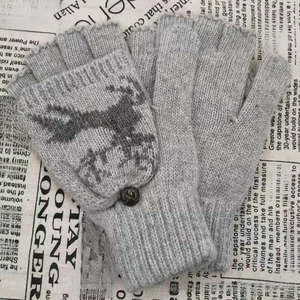 Détail de gants tricotés avec motif de renne et fermeture à bouton pratique