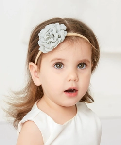 Close-up of a toddler wearing a delicate grey fabric flower headband for kids