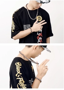 Detail of a men's heavy titanium steel woven chain necklace and bracelet set on a male model