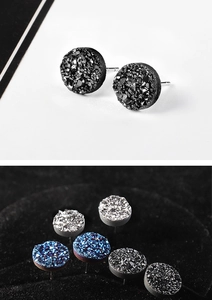 Macro shot of s925 silver stud earrings with sparkling round mineral crystal clusters