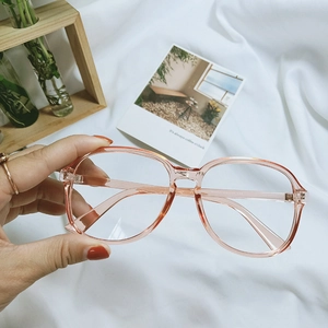 Detail view of transparent pink oversized eyewear frame with subtle temple inscriptions