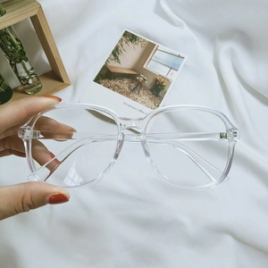 Close-up of transparent large frame glasses with stylish vintage aesthetic on soft fabric