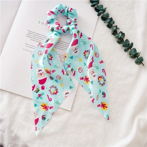 Detailed view of light blue Christmas scrunchie with long ribbon on a book page