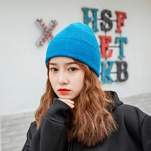 Close-up of blue flecked knit beanie with a folded cuff on a female model