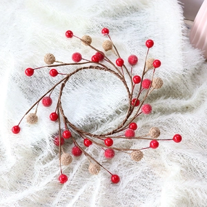 Christmas berry wreath with red and gold beads on white faux fur background
