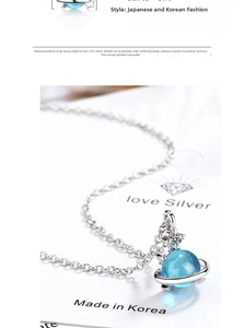 Macro shot of silver planet pendant with blue stone and star zircon on necklace
