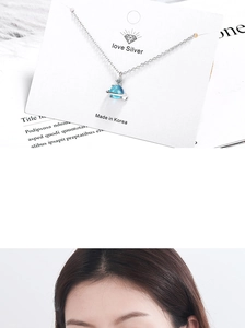 Detail of blue planet pendant necklace on display card with silver chain and sphere