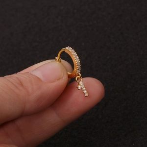 Makroaufnahme goldener Creolen mit Anhänger Nummer 1 und schimmernden Zirkon-Pavé-Steinen