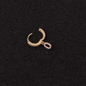 Detailansicht eines goldenen Ohrrings mit Zirkonia-Steinen auf schwarzem Hintergrund