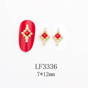 Détail du bijou d'ongle 7x12mm avec pierre rouge et perle sur base dorée modèle LF3336