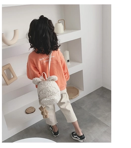Détail d'un sac à dos blanc en sherpa pour enfant avec d'adorables oreilles d'ours