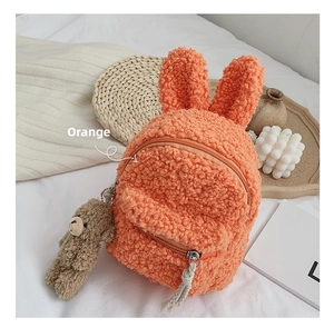 Détail du sac à dos orange en sherpa avec oreilles de lapin et peluche d'ours suspendue