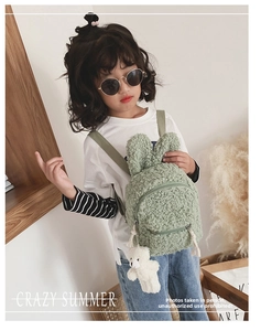 Détail du sac à dos enfant en polaire verte avec oreilles de lapin et petit ours