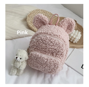 Détail du sac à dos enfant en laine d'agneau rose avec oreilles d'ours et peluche