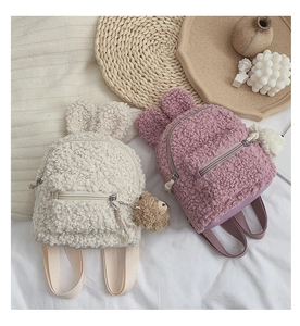 Détail de sacs à dos en peluche avec oreilles de lapin et breloques ours en crème et mauve