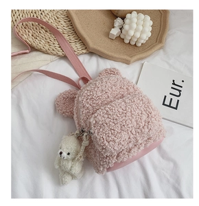 Détail d'un sac à dos enfant en polaire rose avec charm ours en peluche et bretelles