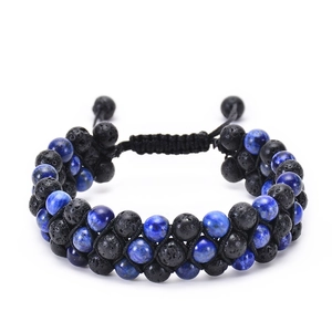 Macro detail of natural lava stone and lapis lazuli beads on a triple-row woven bracelet