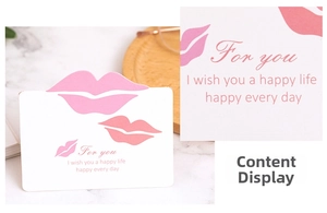 Gros plan d'une carte cadeau blanche avec empreintes de lèvres roses et texte de voeux