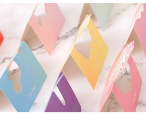 Détail de cartes de vœux avec cœur évidé en papier pastel rose bleu et jaune