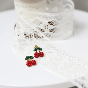 Close-up of gold cherry stud earrings with red and green sparkling rhinestones