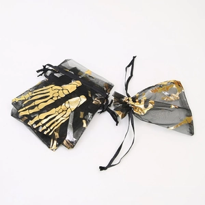 Detail of Halloween organza gift bags with gold skull hand prints on black fabric