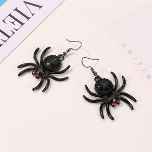 Detail of gothic spider drop earrings with red gems and gear texture in black metal