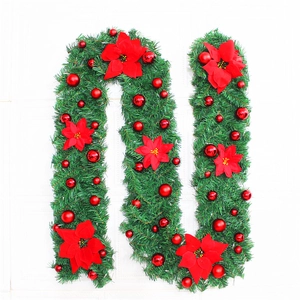 Detailed view of 2.7m Christmas garland with red poinsettias and festive ornaments