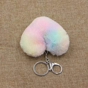 Macro view of a colorful rainbow plush heart keychain on a natural burlap background