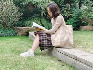 Borsa tote a quadri con manici in pelle in un parco per uno stile casual chic